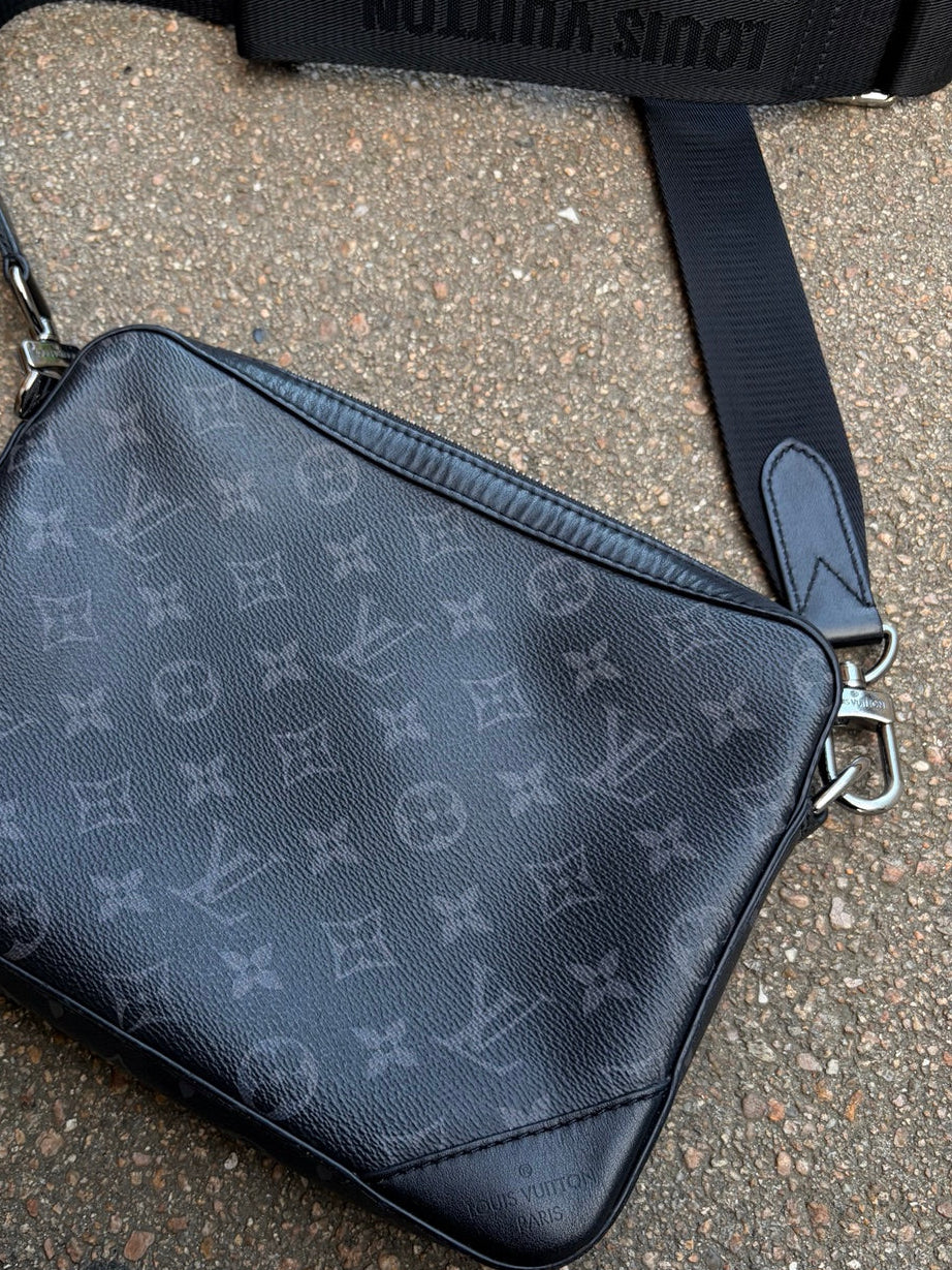 Detalje af Louis Vuitton-monogram, lynlås, rem og metalbeslag på sort crossbody-taske