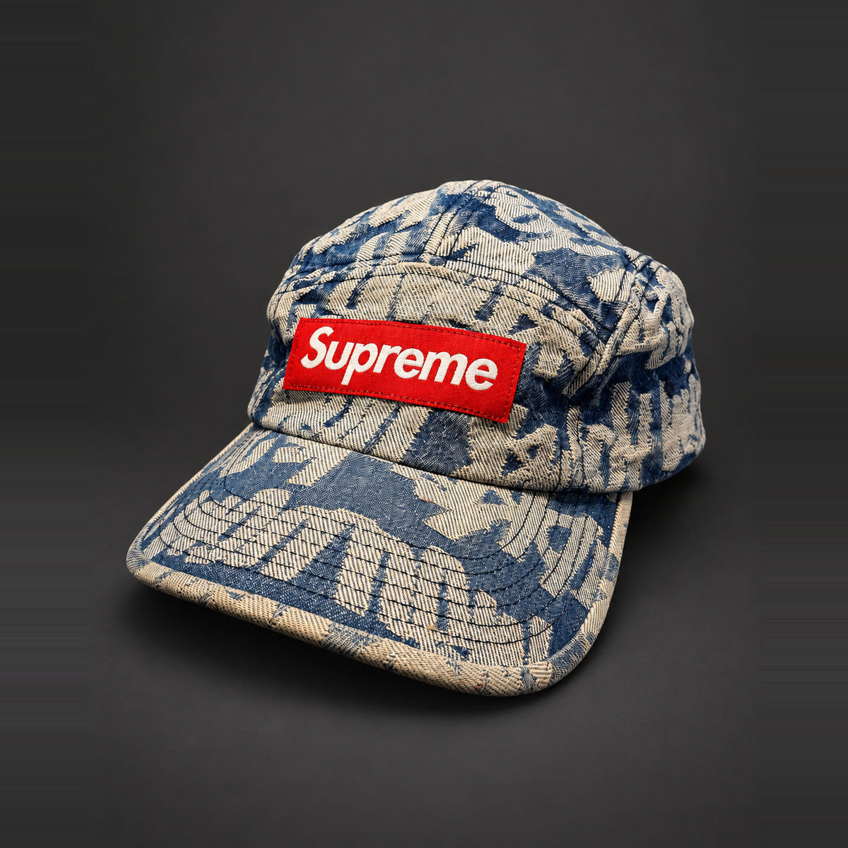 Supreme cap med blåt og beige mønster og rødt Box Logo – AI-redigeret baggrund