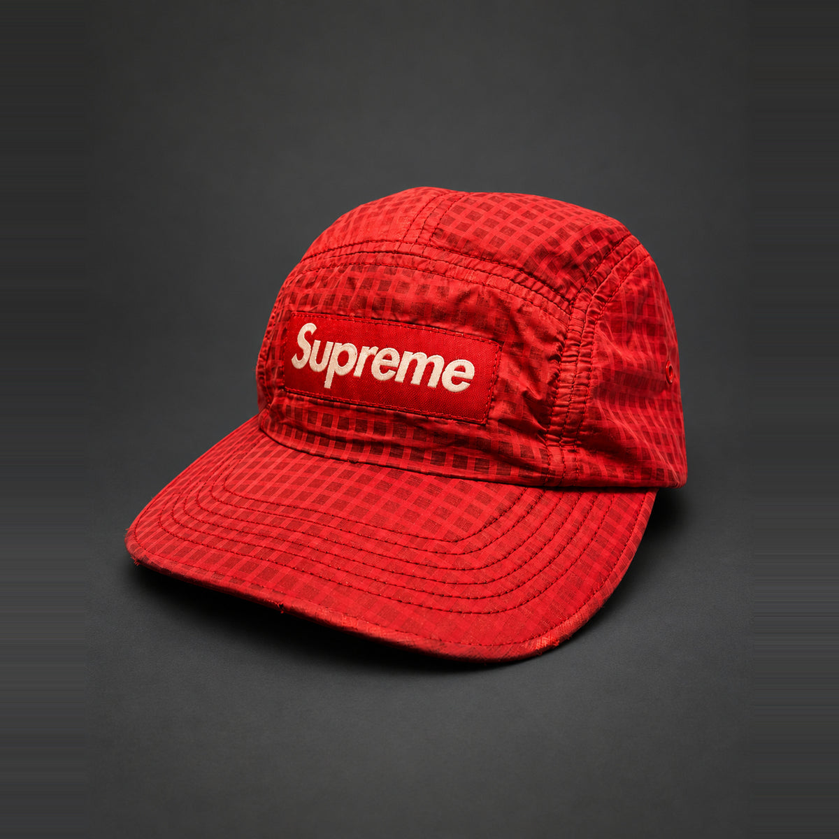 Rød Supreme-cap med tonalt ternmønster og Box Logo – AI-redigeret baggrund