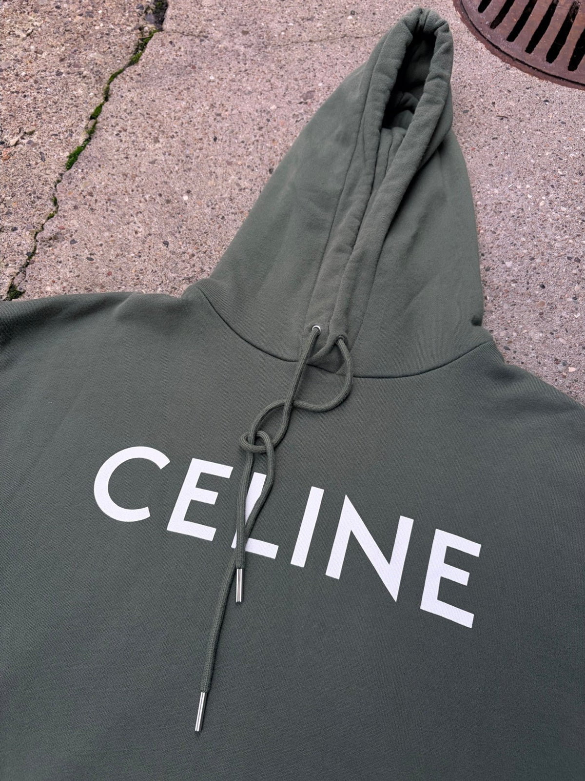 Celine-logo, hætte og snore med metalender på den grønne hoodie